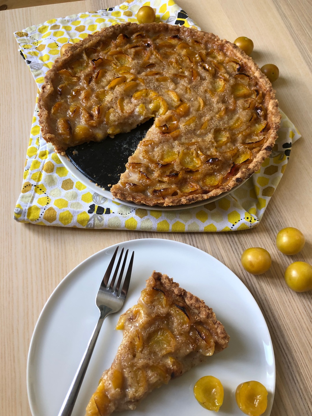 Vertical image of mirabelles tarte with slice on the side