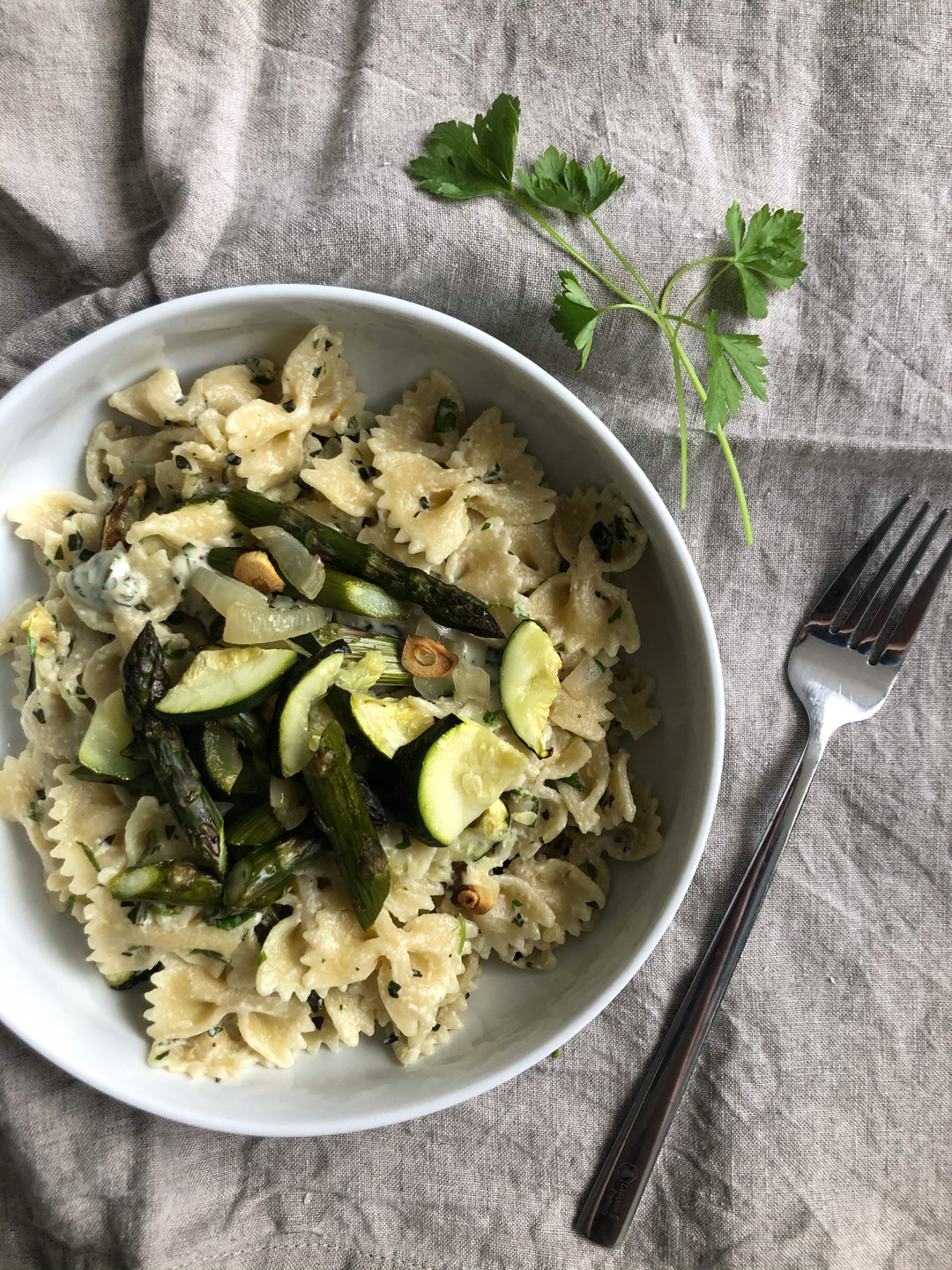 vegan tahini pasta with herbs and green veggies
